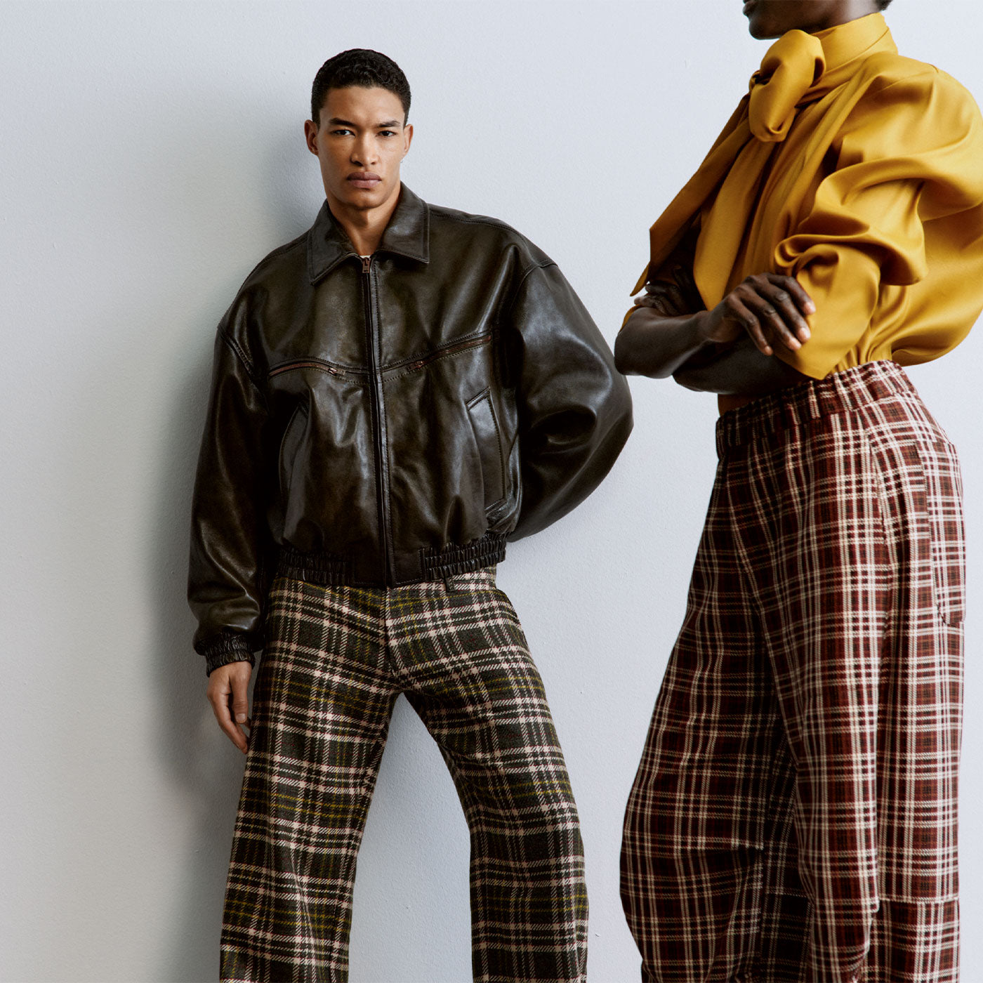 Models wearing contemporary autumn looks with a leather jacket, statement blouse and checked trousers.