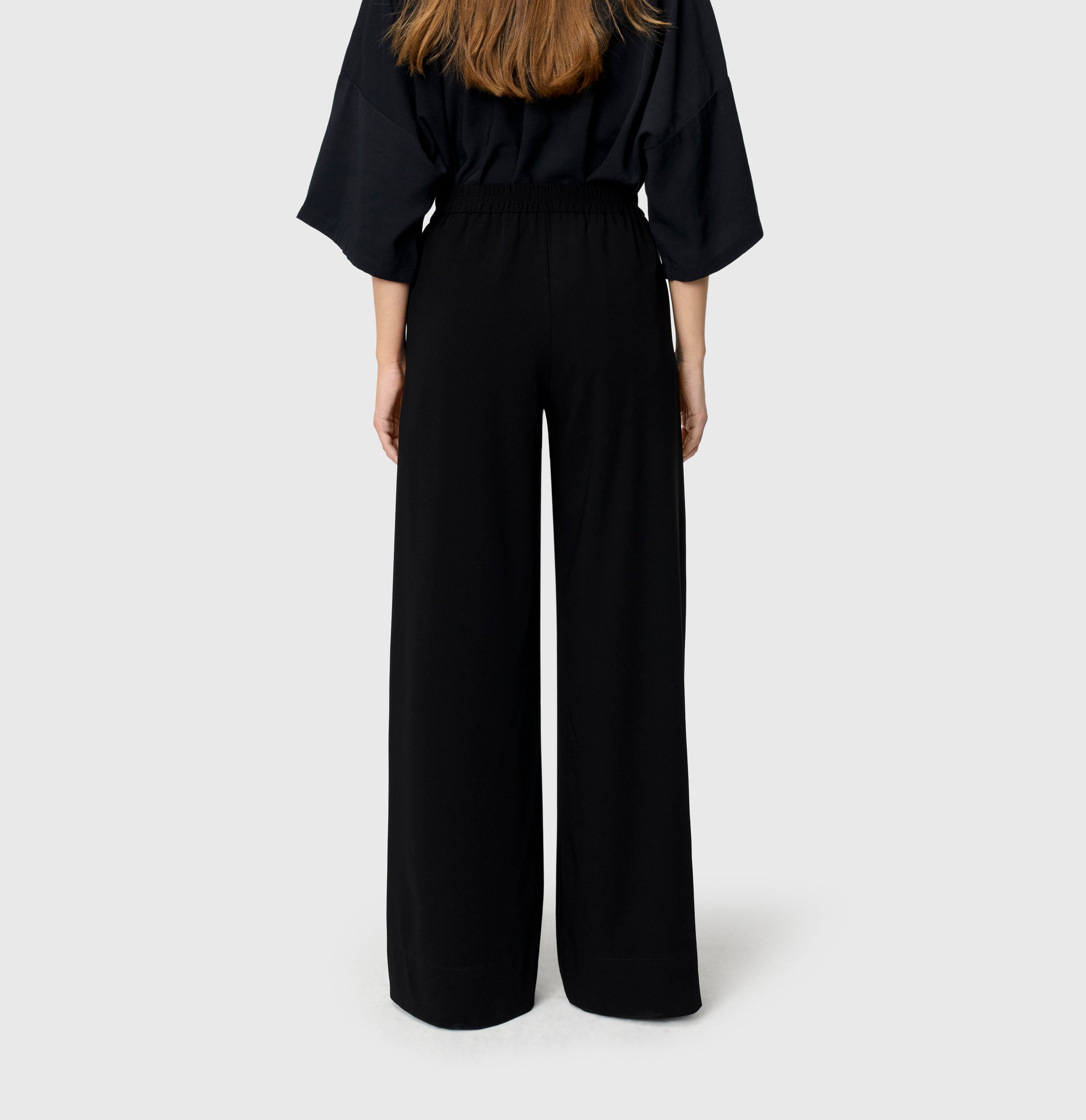 Wide, flowing trousers made of floating crepe. | CORALIE | black | Back view of model