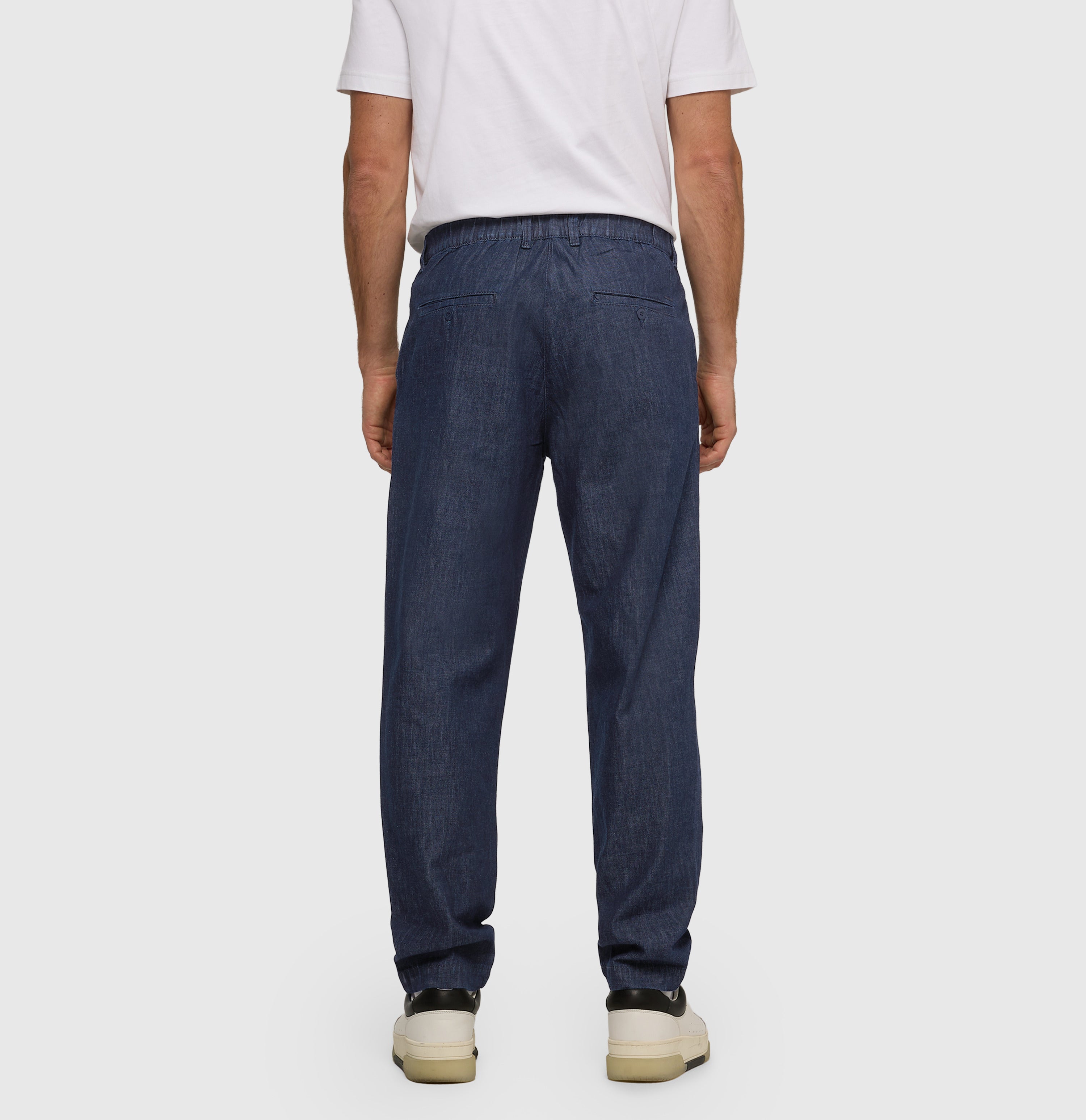 Tapered fit made from light nettle denim. | Dean Pleat | dark rinsewash | Back view of model