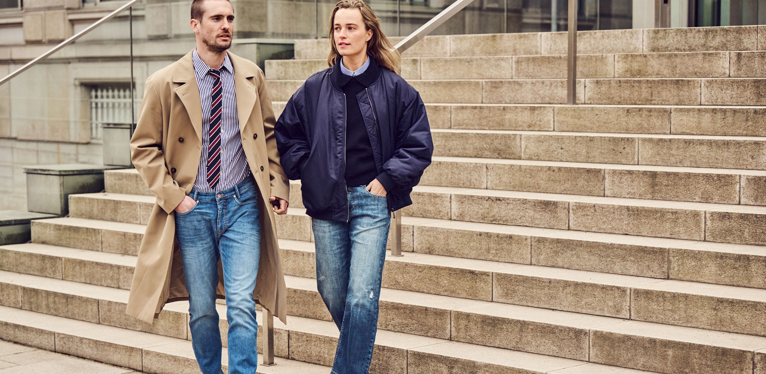 Man and woman wearing modern MAC Jeans denim outfits with trench coat and bomber jacket from the Pre-Season Collection.