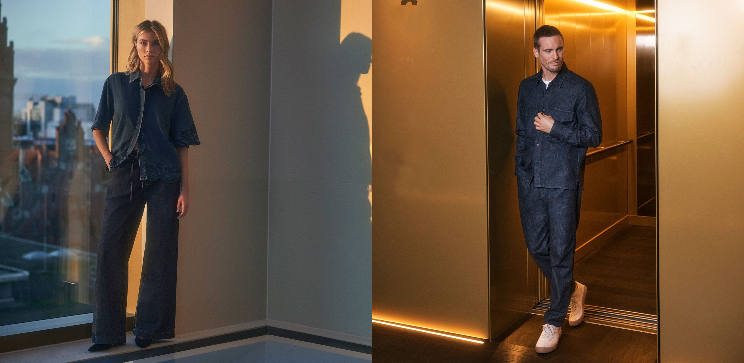 Modern campaign image featuring two fashion models in sophisticated dark denim looks inside a luxury urban interior at golden hour. On the left, a female model stands by floor-to-ceiling windows wearing a relaxed indigo denim blouse with embroidered sleeve and hem details paired with wide-leg jeans. On the right, a male model steps out of a gold-lit elevator wearing a coordinated dark denim overshirt and slim-fit jeans with white sneakers. Warm cinematic lighting, elegant reflections, premium lifestyle atmo