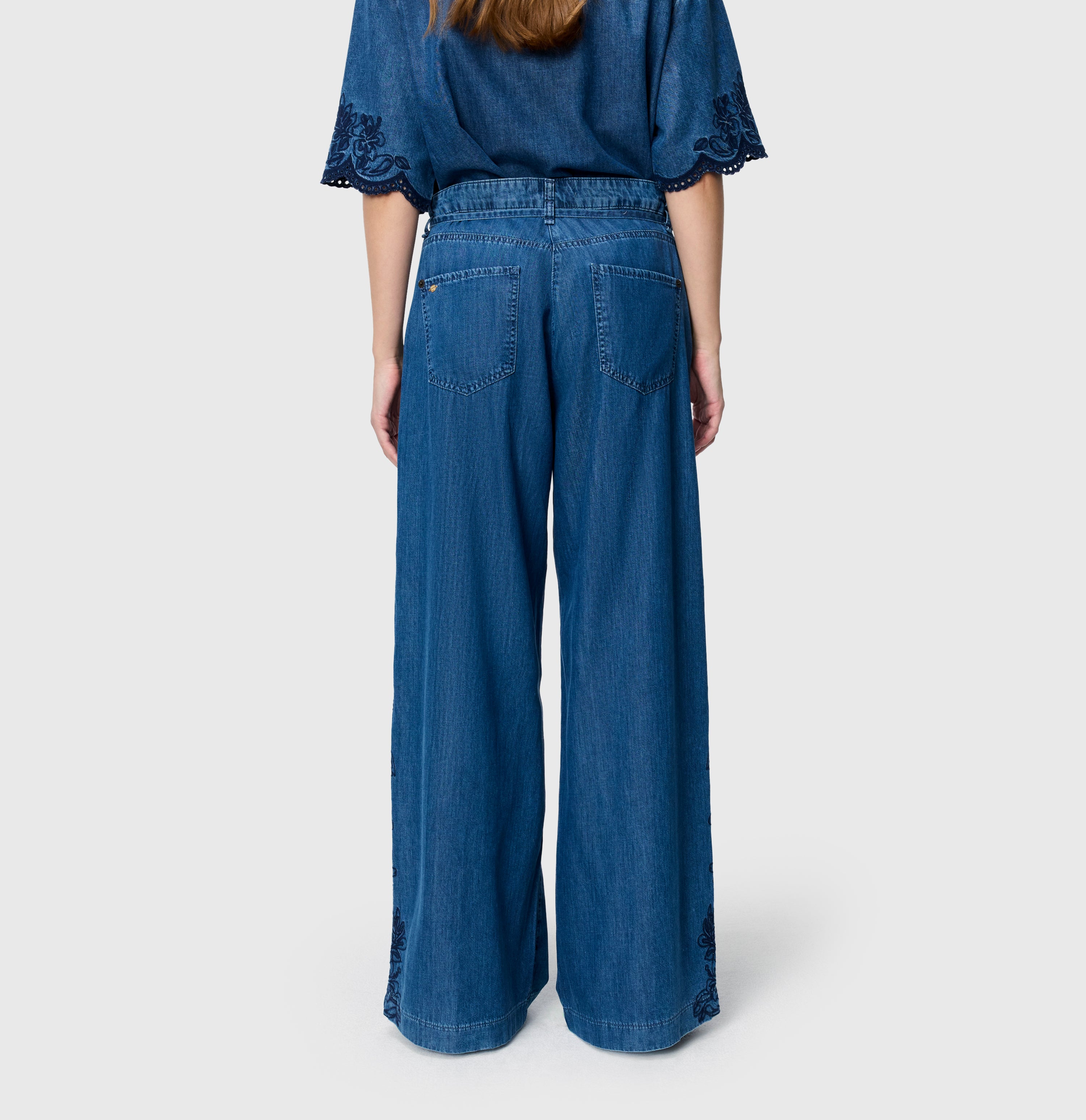 Light, wide jeans with floral embroideries. | WENDY embro | mid blue heritage wash | Back view of model
